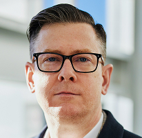 Alexander Hughes, CEO e dirigente di un'azienda di compravendita di criptovalute, in un ritratto